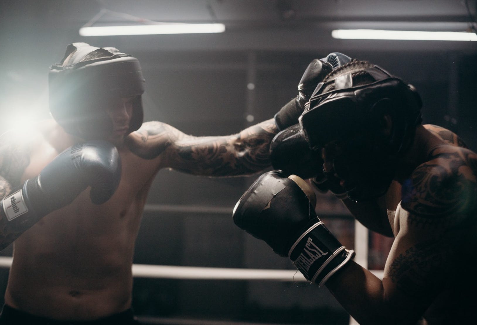 two boxers fighting in a match wearing protective head gear