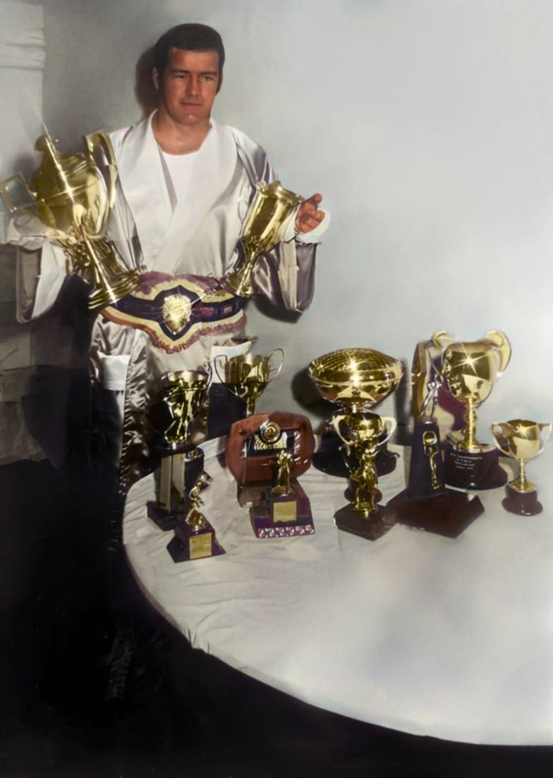 Eddie McGarry stood next to his medal and trophies he has won 